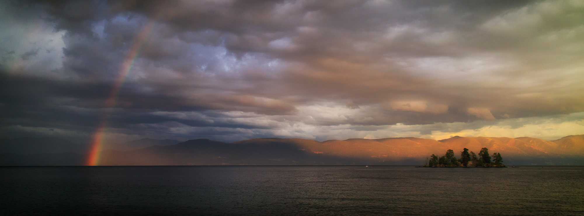 Flathead Lake on a calm evening, with mountains along the far shore.